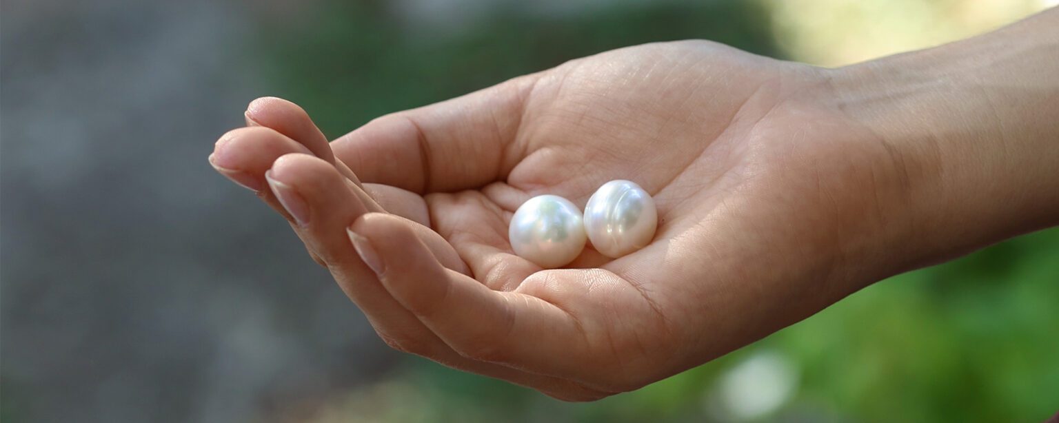 Customer holding a couple of pearls in her palm which would make the perfect pearl jewellery gift.